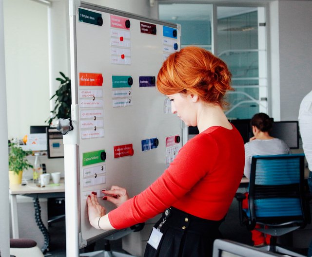Young professional woman filling an accountability board