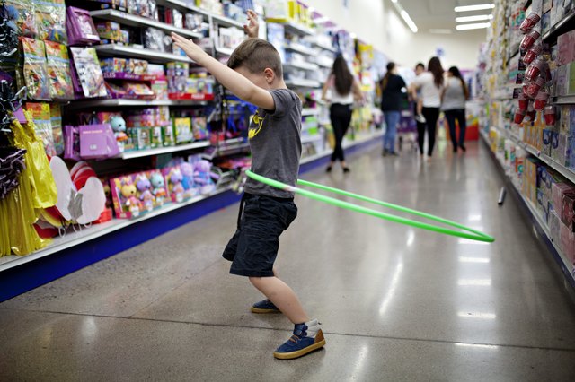 boy hula hooping in the aisle of a dollar store