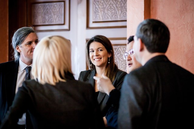 Woman smiling amid colleagues all in business suits