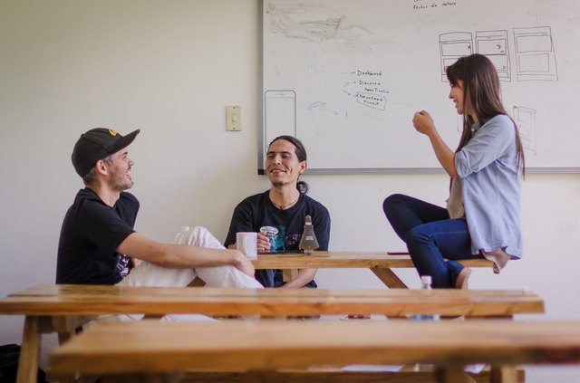 Three young professionals chatting at a table