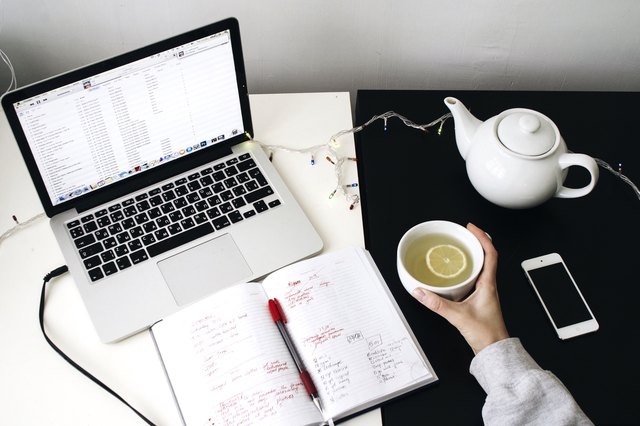 Overhead shot of laptop notebook teapot iphone hand