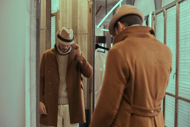 Man posing in store mirror with outfit