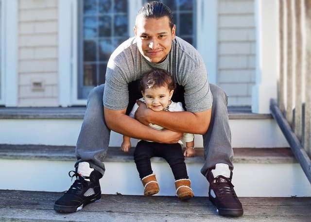 Happy Hispanic Dad and daughter sharing a loving moment outside on the steps of their house
