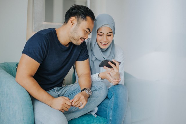 Cute couple both looking at phone screen