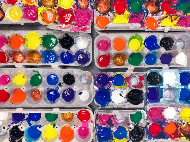 Many colors of paint in eight egg cartons