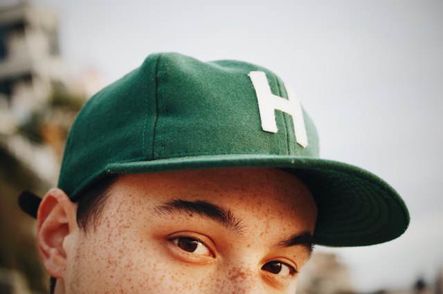 Young person with freckles and a green cap