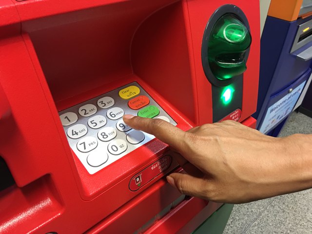 Woman's hand typing on ATM keypad