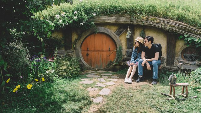 Couple sitting in front of hobbit house