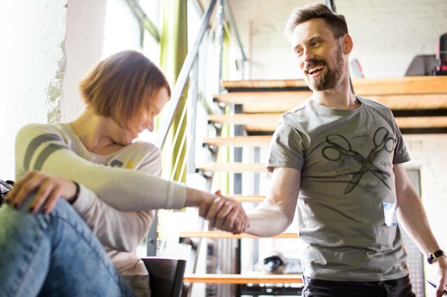 Young white man shaking hands with a white woman