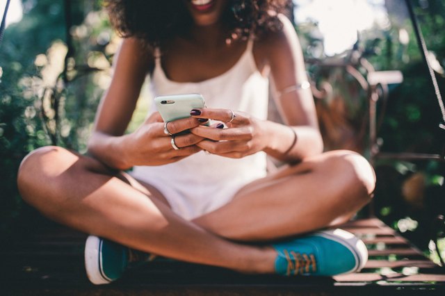 Young Black woman sitting and texting
