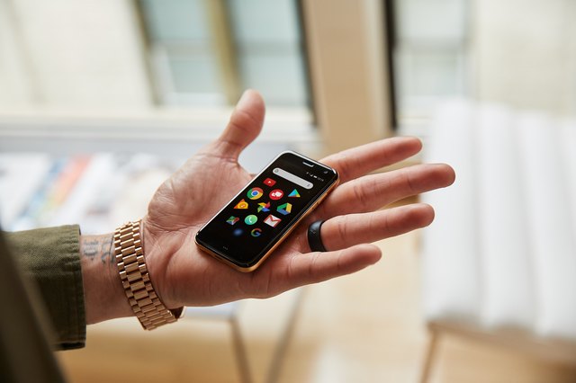 Man's hand holding tiny Palm smartphone
