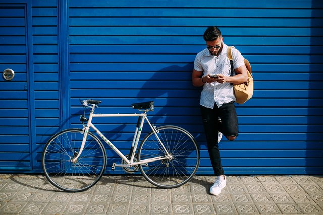 Man with bicycle against blue wall