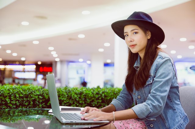 A young hipster freelancer working in open office with her laptop