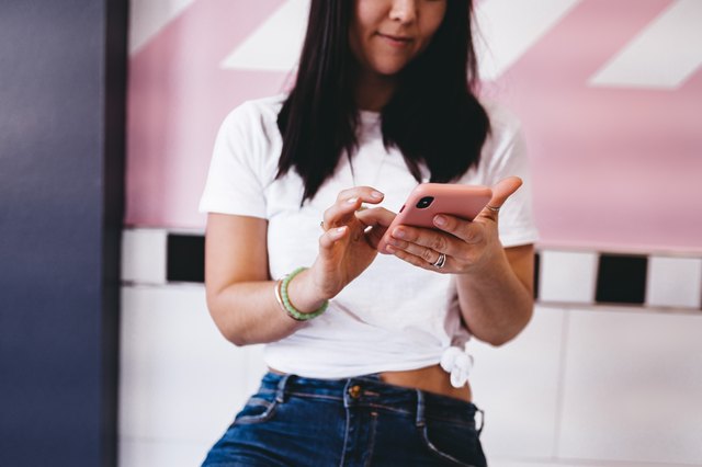 Woman using mobile phone in pink case