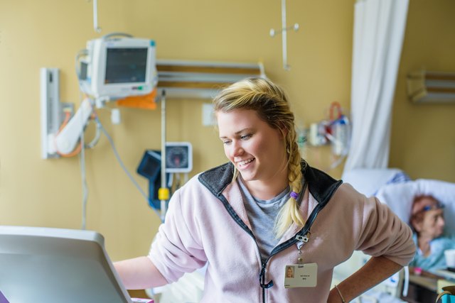 Health care professional at monitor in patient area