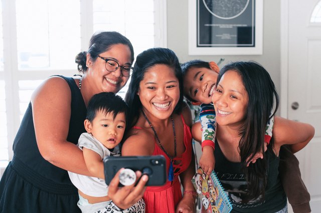 Three adult women and two kids taking a fun selfie