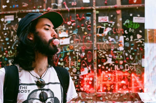Young man blowing bubblegum in urban scene