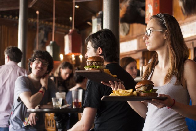 Waitress carrying plates of burgers