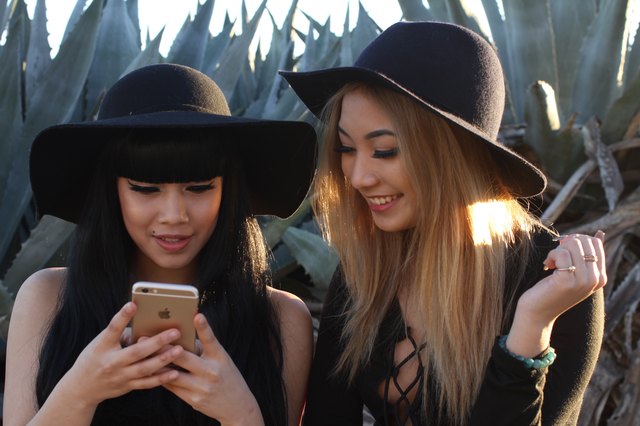 Two fashionable young women looking at an iPhone