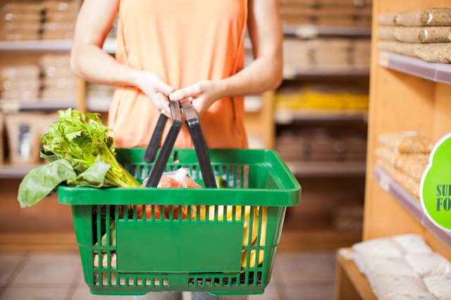 Vrouw met sommige boodschappen in een mandje