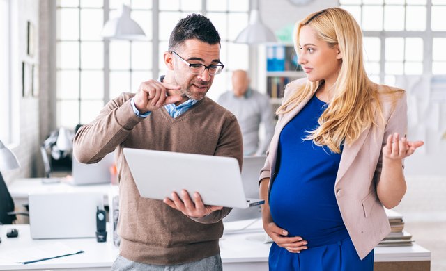 Coworker explaining something to pregnant woman