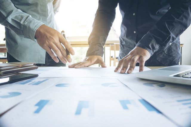 Midsection Of Business People Working At Table