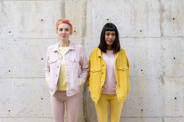 Two alternative friends having fun, wearing yellow and pink jeans clothes