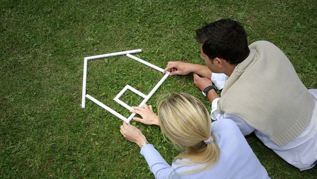 Couple holding hands by open house