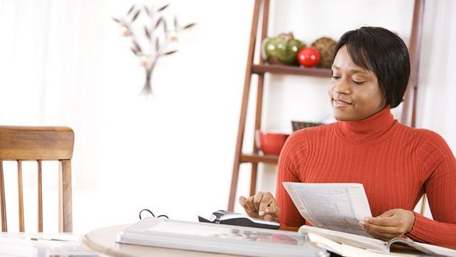 Overwhelmed woman with paperwork and laptop