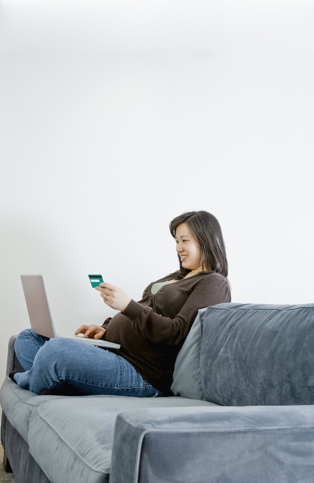 Pregnant Asian woman buying merchandise over the internet