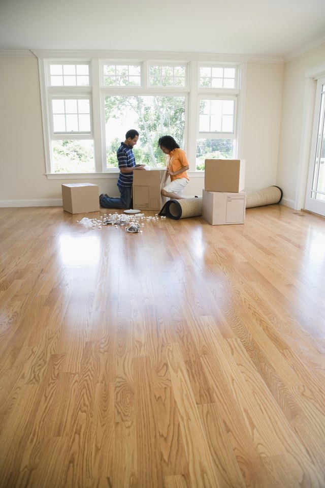 Side profile of a mid adult woman and a young man looking in a cardboard box