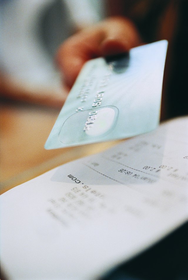 Receipt and a Person Paying With a Credit Card