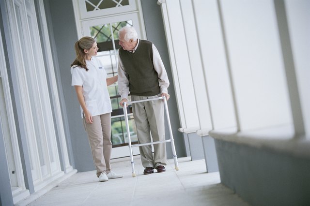 Nurse helping man with walker
