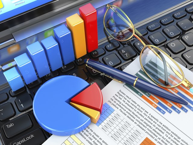 Business office concept. Graph and charts on laptop keyboard.
