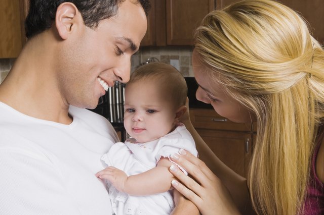 Hispanic parents smiling at baby