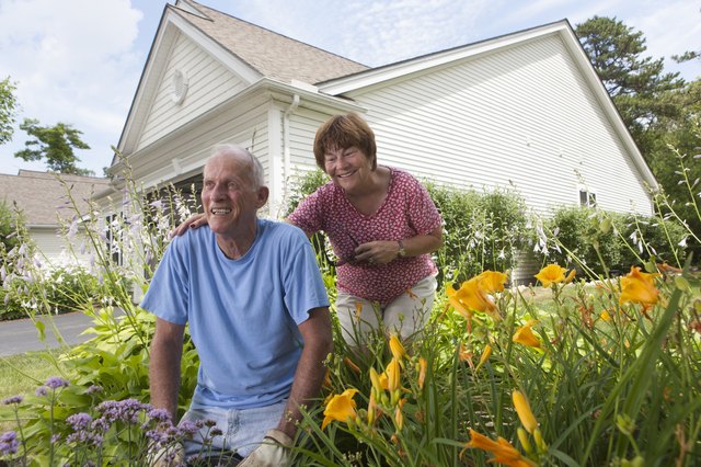 Senior couple preparing to plant flowers in garden
