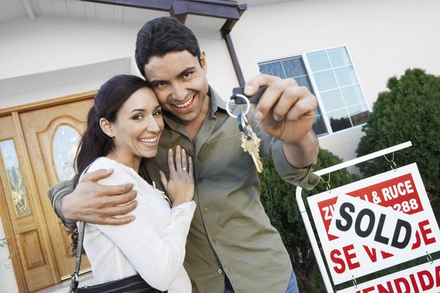 Happy Homeowners with <Sold> Sign