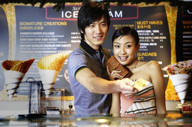 Man and woman using credit card to buy ice cream
