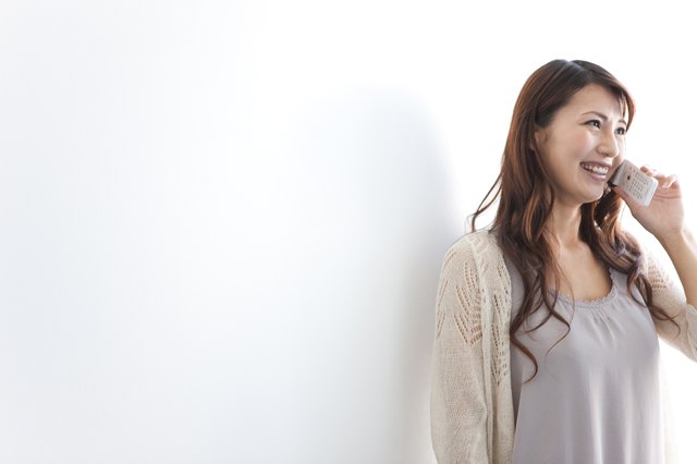 Young woman using mobile phone, white background, copy space