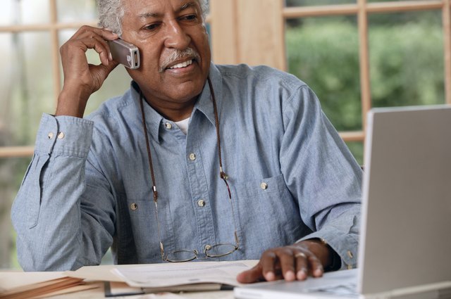 Man with laptop talking on telephone