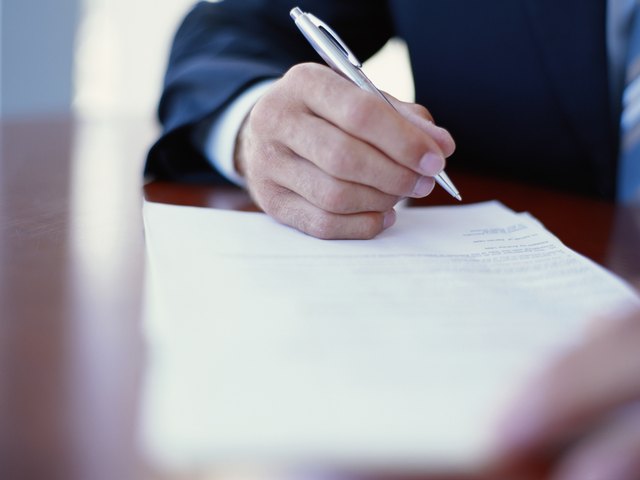 Businessman writing at desk, close-up