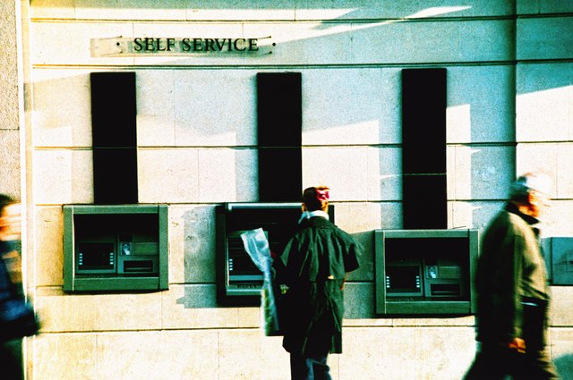a person standing at an automatic transaction machine