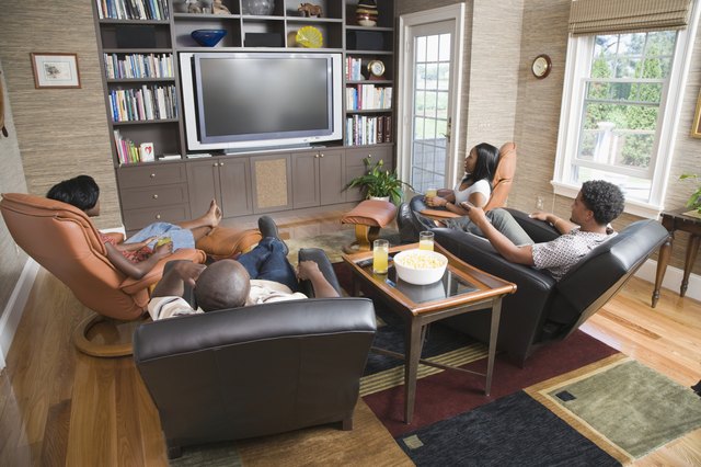 High angle view of two young couples sitting in front of a television in a living room