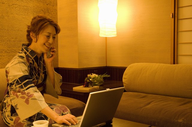 Woman talking on a mobile phone and using a laptop