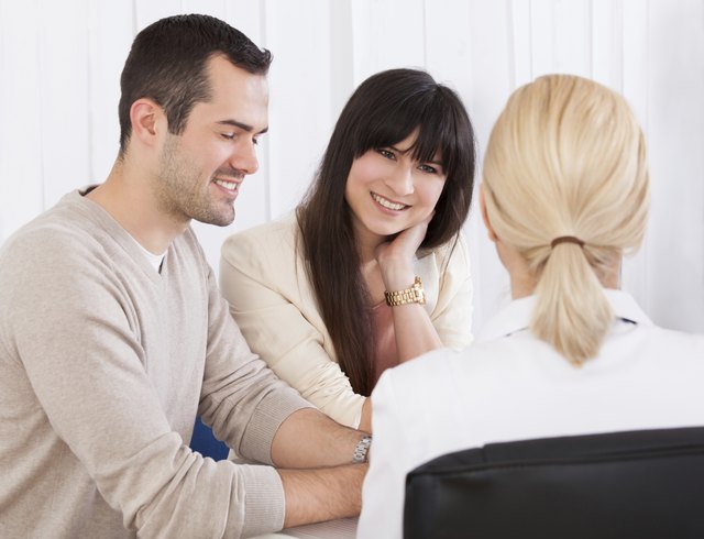 Happy Doctor Discussing With Couple