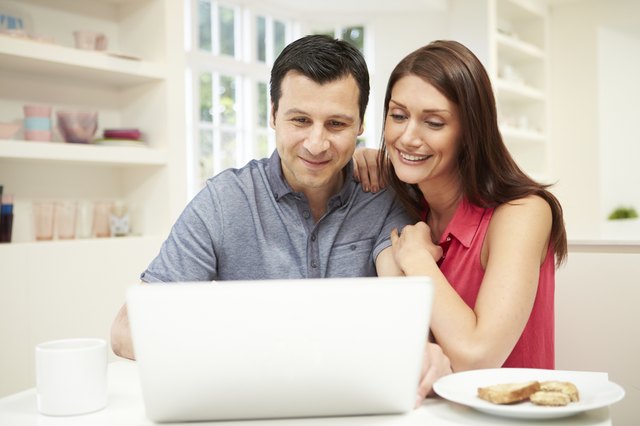 Couple Looking at Laptop Over Breakfast