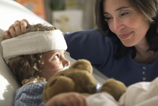 a caucasain mother visits and consoles her young child as she lays recovering in the hospital