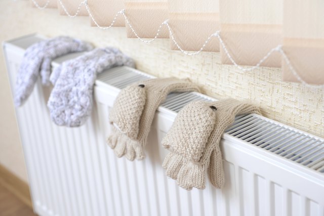 Knitted gloves drying on heating radiator