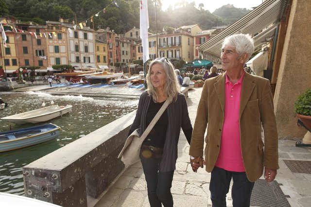 Senior couple walking by the water, Italy
