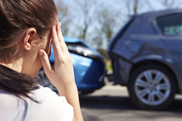 Stressed Driver Sitting At Roadside After Traffic Accident